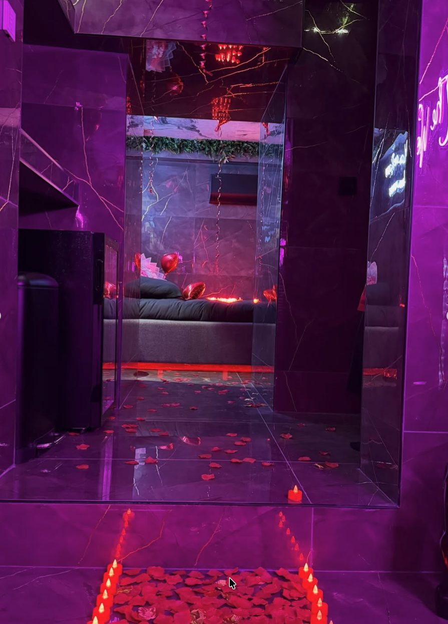 Grand miroir reflétant le lit décoré de bougies et de ballons en forme de cœur